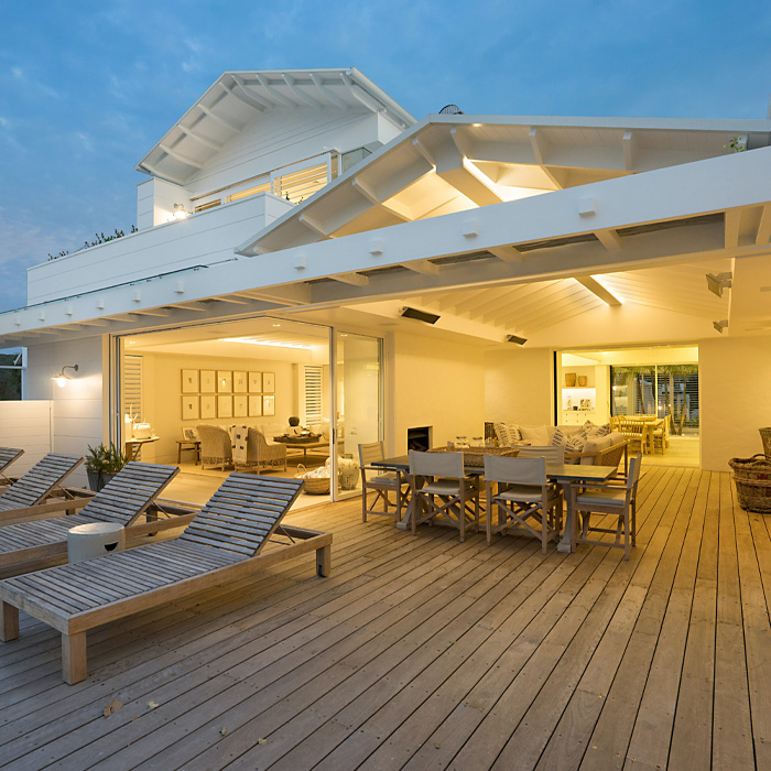 White wooden covered deck with outdoor furniture showcasing creative backyard deck ideas for relaxing and entertaining outdoors.