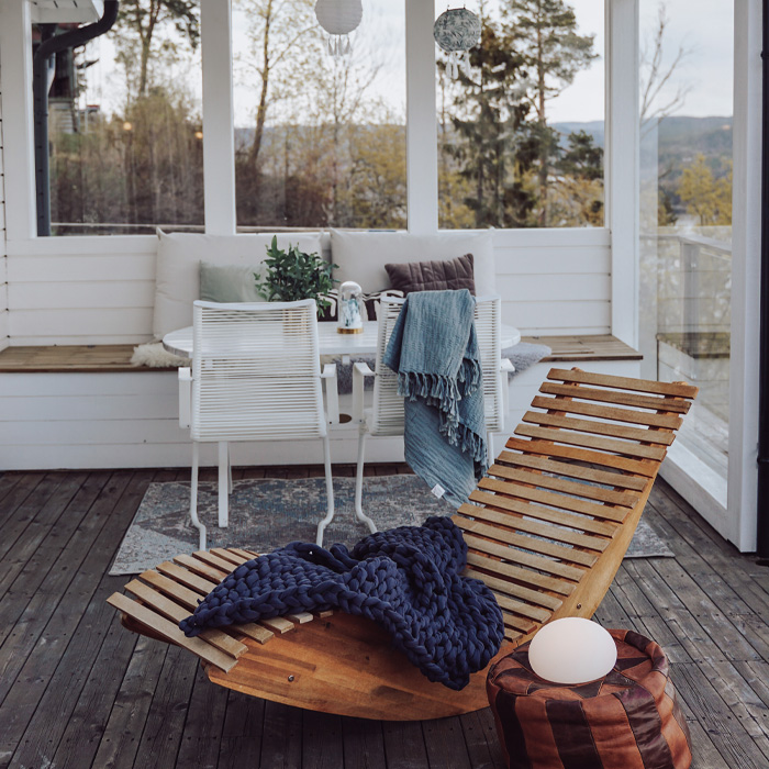 Wooden armchair with cozy blanket on a creative backyard deck enhancing your time outdoors with stylish comfort.