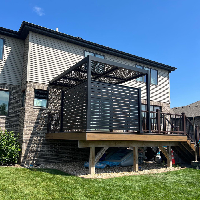 Modern backyard deck with a privacy screen and pergola providing a stylish outdoor living space to enhance your time outdoors