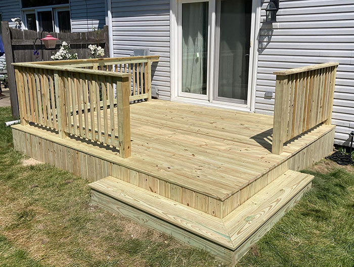 Pine wood deck with classic deck railing design, enhancing exterior style and outdoor living space.