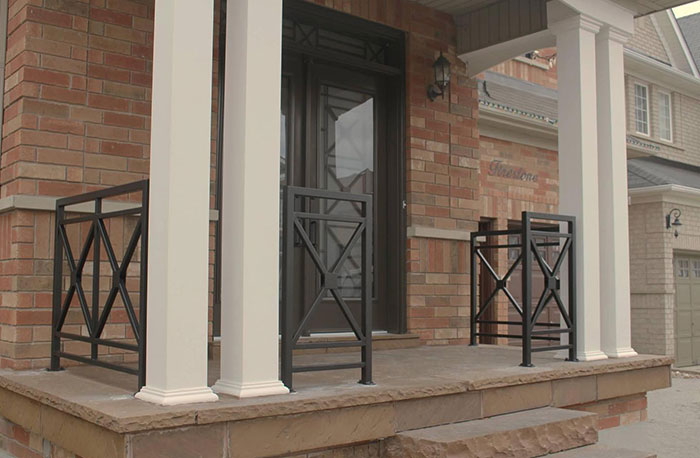 Black metal deck railing with criss-cross design on a front porch enhancing exterior deck railing ideas.
