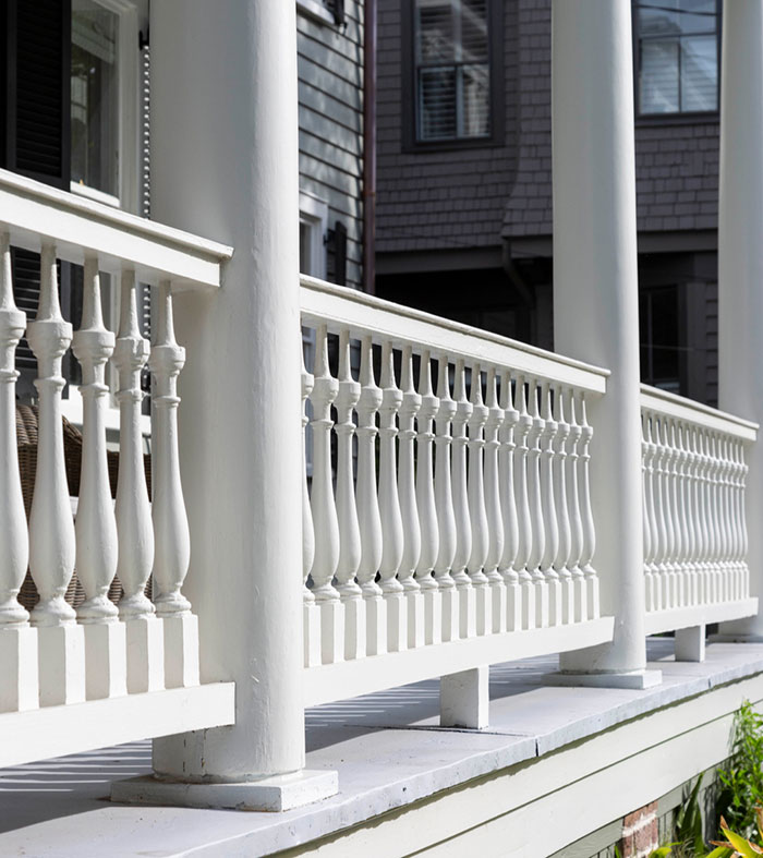 White colonial deck railing featuring classic balusters and sturdy columns enhancing exterior deck design ideas.