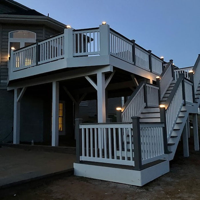 Black and white geometric deck railing design on an elevated porch with stairs and modern outdoor lighting.