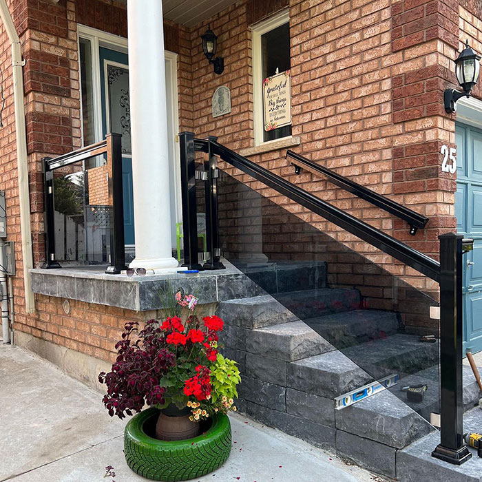 Tinted glass single-panel deck railing with black metal posts enhancing modern exterior deck design.