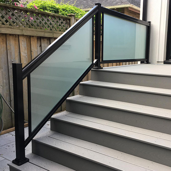Black deck railing with blurred glass panels enhancing modern deck railing ideas and designs outdoors.