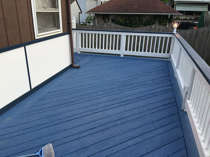 Black and white deck railing design on a blue porch deck, showcasing modern deck railing ideas and exterior style.