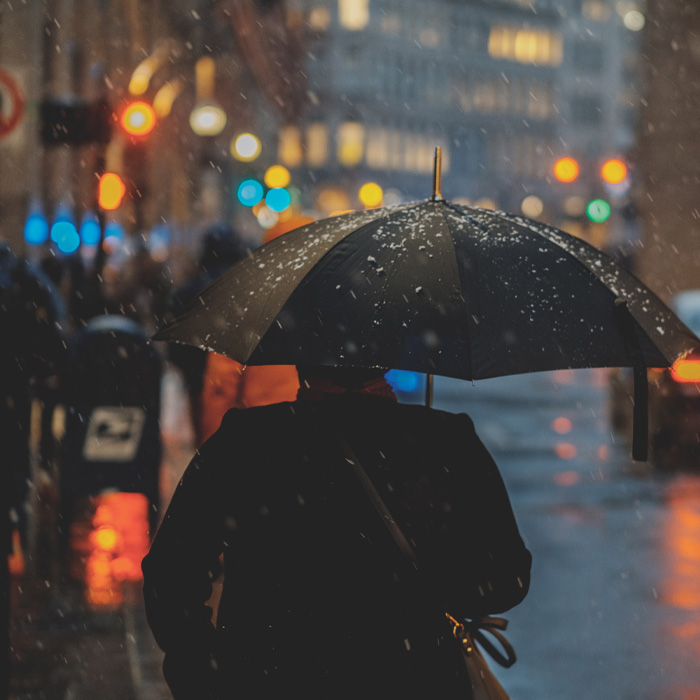 Person walking on the street with an umbrella 