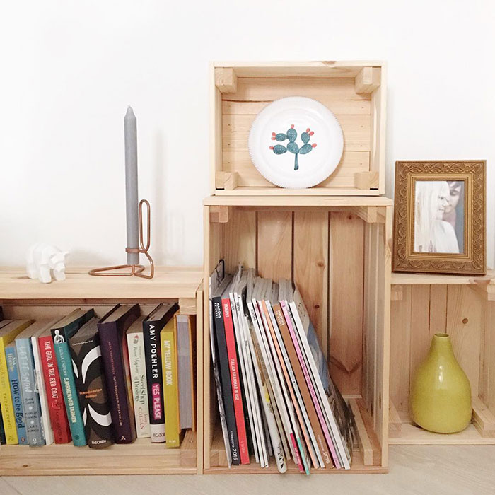 Wooden box assembly for extra storage, showcasing DIY modern floating nightstand ideas with books and decorative items.