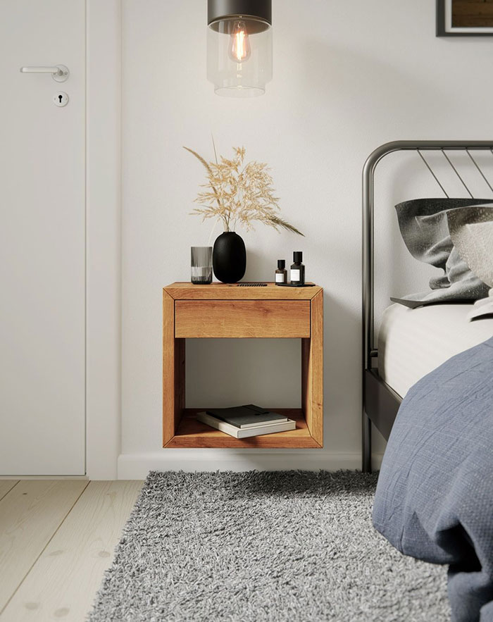 Spacious modern floating nightstand with a drawer, decorative vase, and bedside essentials in a minimal bedroom setting.
