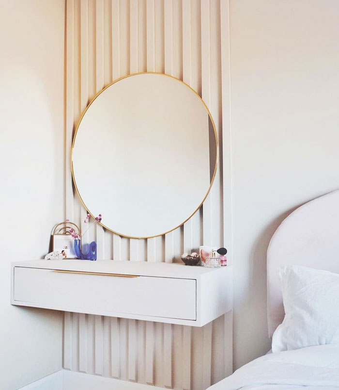 Minimalist multipurpose modern floating nightstand with a round mirror, mounted in a stylish bedroom corner.