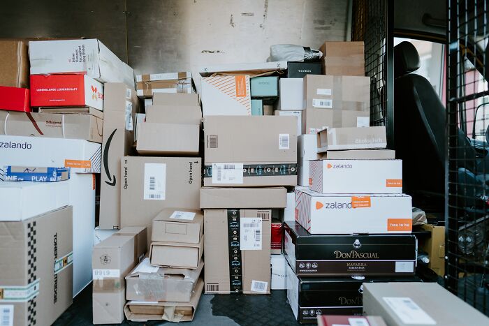 Boxes stacked inside a delivery truck, showcasing a variety of packaging and brands.