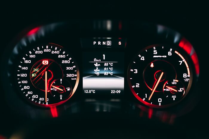 Close-up of car dashboard with speedometer and tachometer, evoking shower thoughts questions.