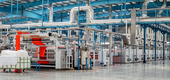 Modern industrial facility with large machinery and metal pipes, illustrating innovation in a manufacturing setting.