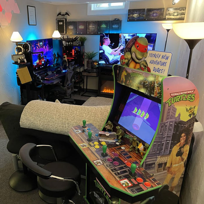 Colorful and bright game room featuring a Teenage Mutant Ninja Turtles arcade cabinet and dual gaming PC setup. Colorful and bright game room featuring a Teenage Mutant Ninja Turtles arcade cabinet and dual gaming PC setup.