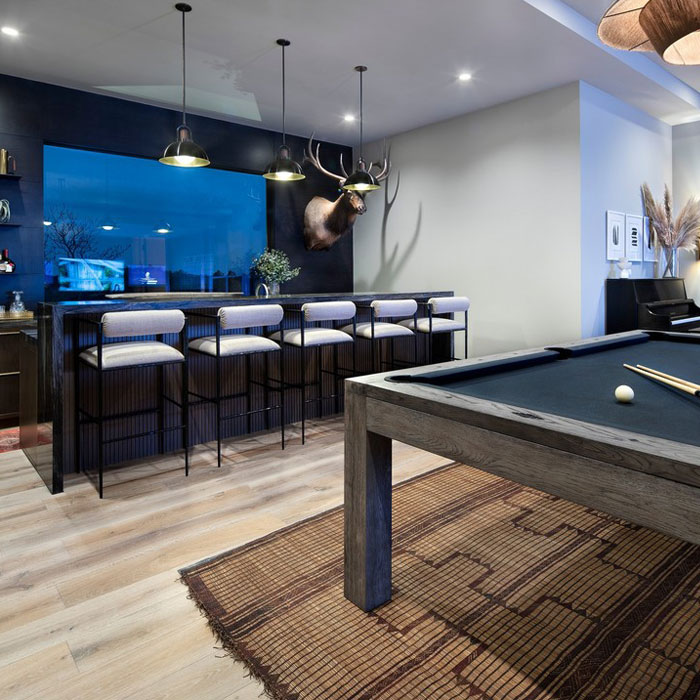 Bar and pool table in a bright game room featuring modern seating and stylish lighting for game room ideas. Bar and pool table in a bright game room featuring modern seating and stylish lighting for game room ideas.