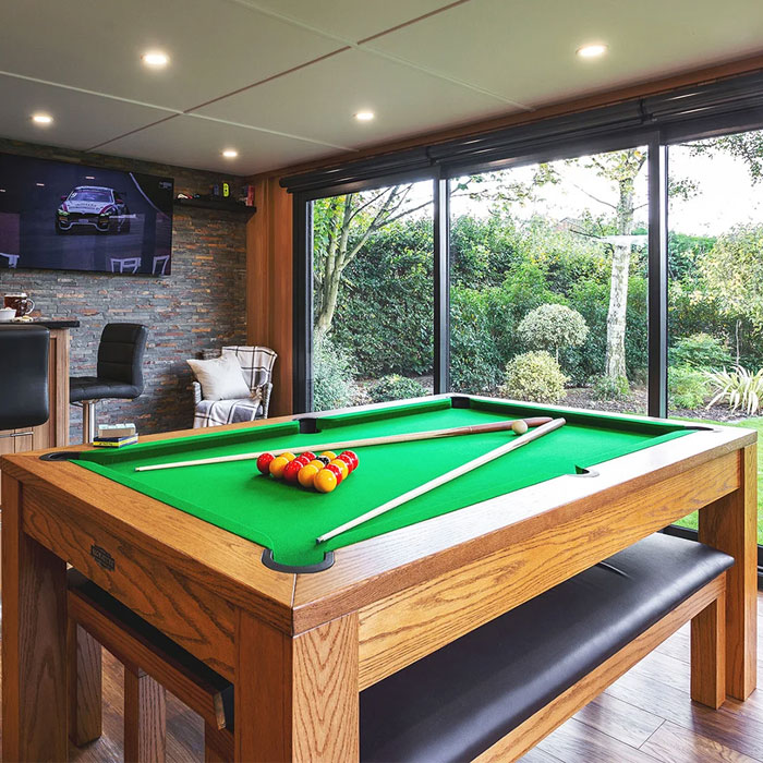 Outdoorsy game room with wooden pool table, large windows overlooking greenery, creating a perfect gaming cave atmosphere Outdoorsy game room with wooden pool table, large windows overlooking greenery, creating a perfect gaming cave atmosphere