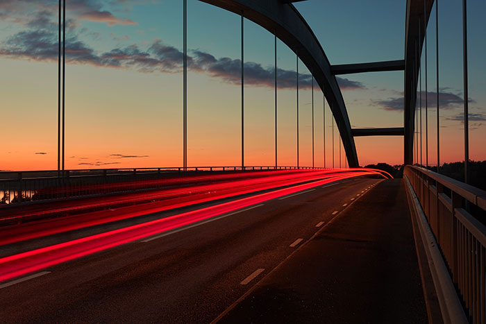 Sunrise light trail on a bridge
