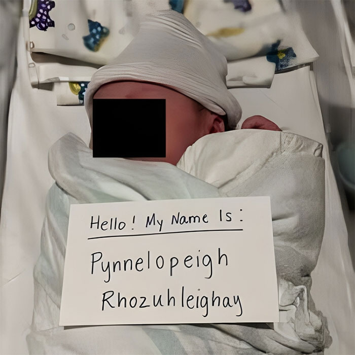 Newborn with a sign showing unusual names, emphasizing unique and creative baby names.