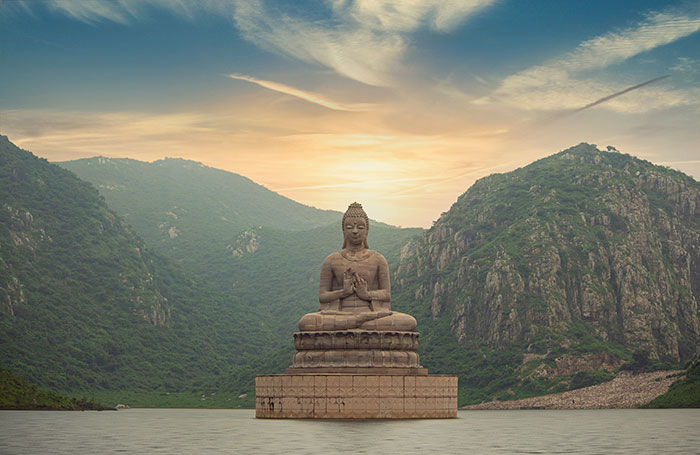 brown buddha statue near green mountain under blue sky during daytime