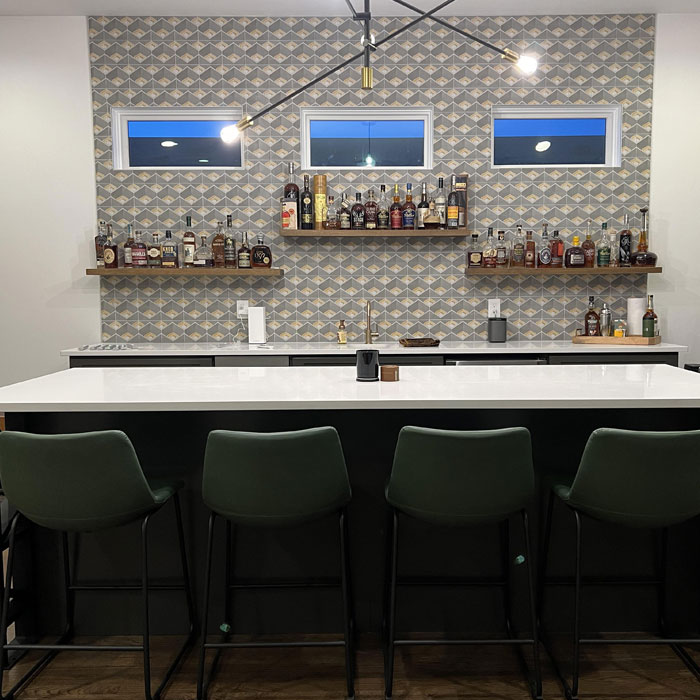 Aesthetic bright home bar with green chairs and a patterned backsplash showcasing stylish home bar ideas. Aesthetic bright home bar with green chairs and a patterned backsplash showcasing stylish home bar ideas.