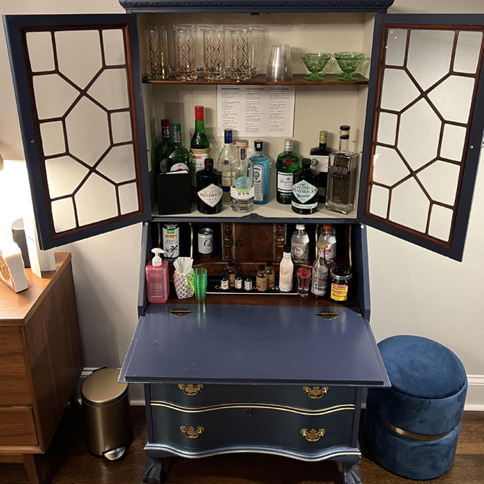 Vintage desk converted into a stylish home bar setup, showcasing bottles, glasses, and bar accessories for happy hour. Vintage desk converted into a stylish home bar setup, showcasing bottles, glasses, and bar accessories for happy hour.