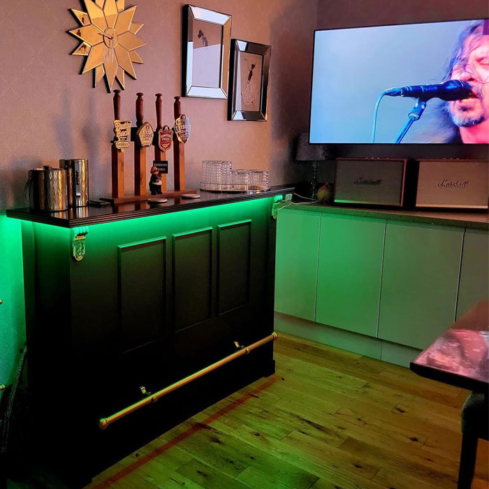 Small home bar with green LED lights, beer taps, and speakers creating a cozy space for home bar ideas and happy hour vibes. Small home bar with green LED lights, beer taps, and speakers creating a cozy space for home bar ideas and happy hour vibes.