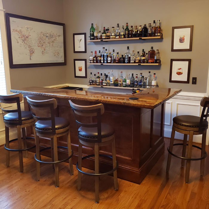 Brownish home bar with wooden stools and shelves stocked with bottles, showcasing cozy home bar ideas for happy hour. Brownish home bar with wooden stools and shelves stocked with bottles, showcasing cozy home bar ideas for happy hour.