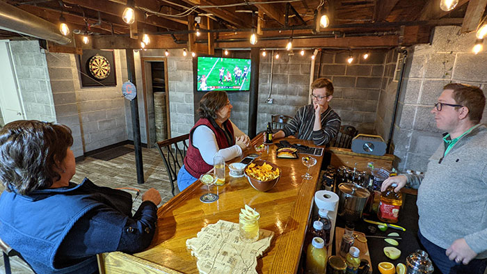 People enjoying drinks and snacks at a cozy basement home bar designed for relaxed happy hour gatherings. People enjoying drinks and snacks at a cozy basement home bar designed for relaxed happy hour gatherings.