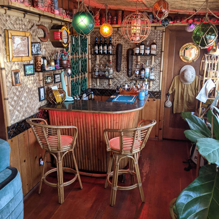 Colorful tiki themed home bar with bamboo stools, hanging lanterns, and tropical decor for a cozy home bar setting Colorful tiki themed home bar with bamboo stools, hanging lanterns, and tropical decor for a cozy home bar setting