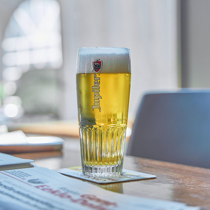 Beer glass on a coaster on a table showcasing a stylish home bar idea for a happy hour at any hour setting. Beer glass on a coaster on a table showcasing a stylish home bar idea for a happy hour at any hour setting.