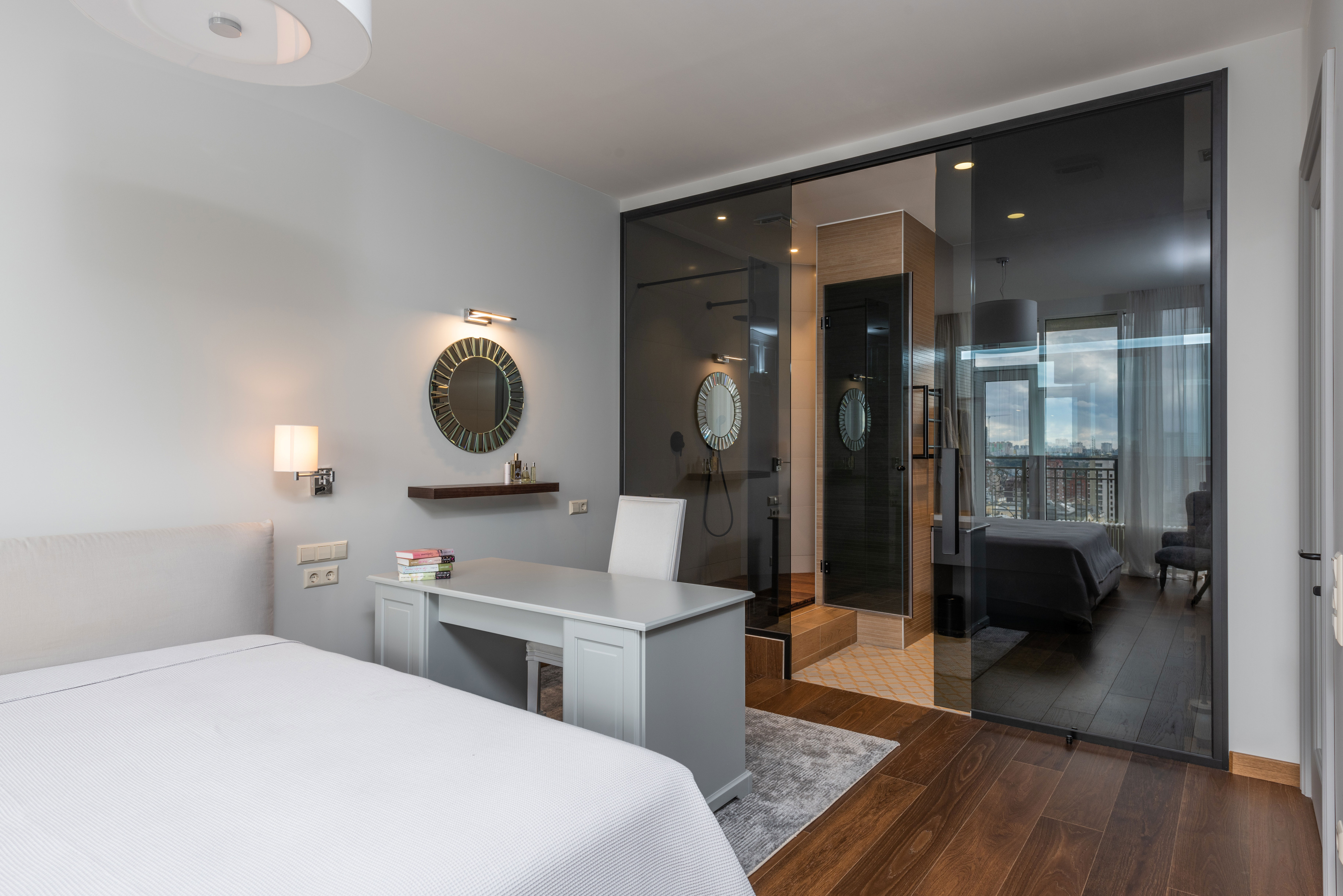 Modern bedroom with big bed and desk setup featuring a chair, ideal for home office ideas to boost productivity.