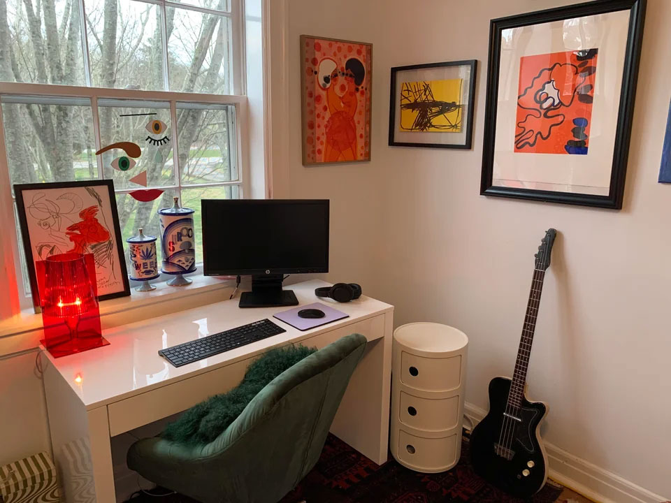Home office ideas featuring colorful art pictures on the wall, a clean desk setup, and a cozy chair for productive work.