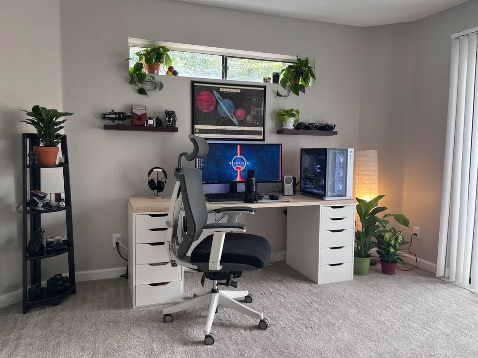 Modern home office setup with monitor, shelves, and plants creating an inspiring and productive workspace design.