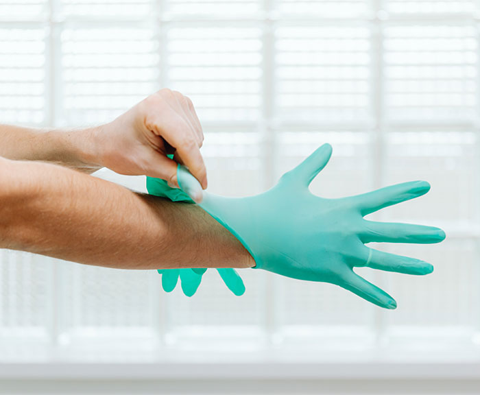 Close Up of Doctor Hands Putting on Gloves Close Up of Doctor Hands Putting on Gloves
