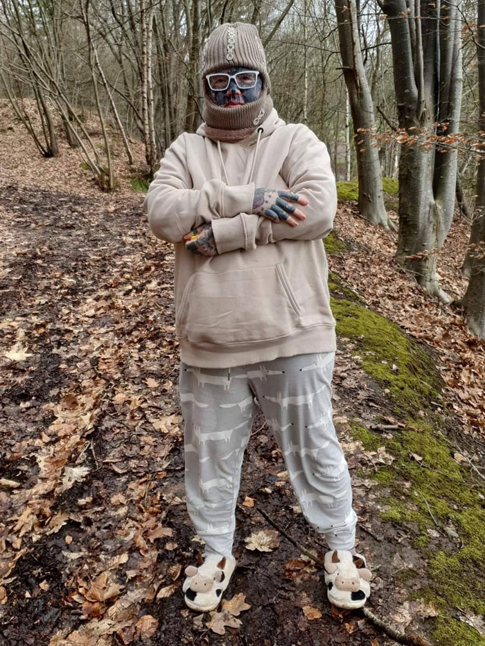 Person with 800 tattoos in woods wearing beige winter clothes and glasses, discussing unemployment challenges. Person with 800 tattoos in woods wearing beige winter clothes and glasses, discussing unemployment challenges.