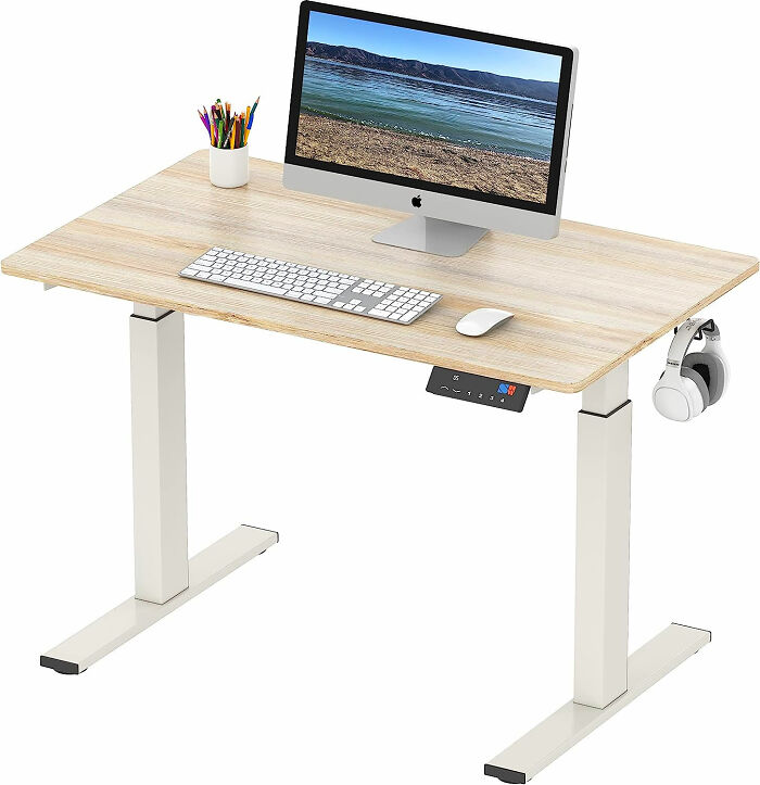adjustable wooden and metal desk with MacBook computer