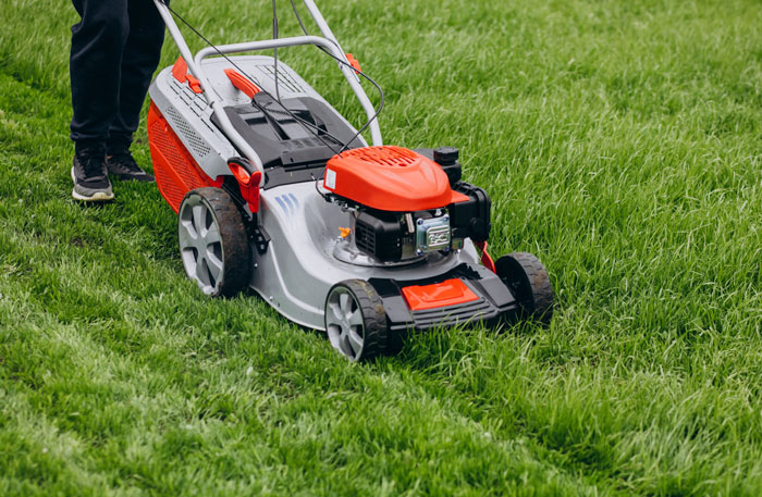 Man cutting grass with lawn mover