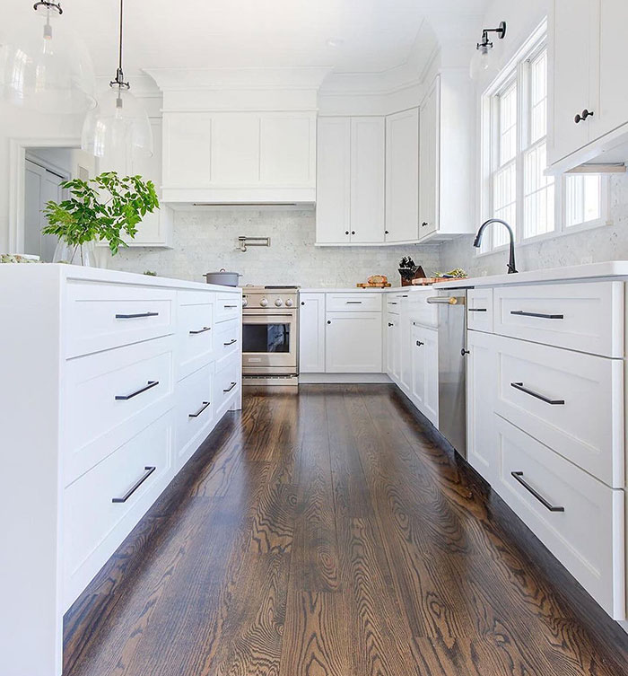 Bright white kitchen featuring Jacobean colored floor showcasing Minwax stain colors for wood stain choices.