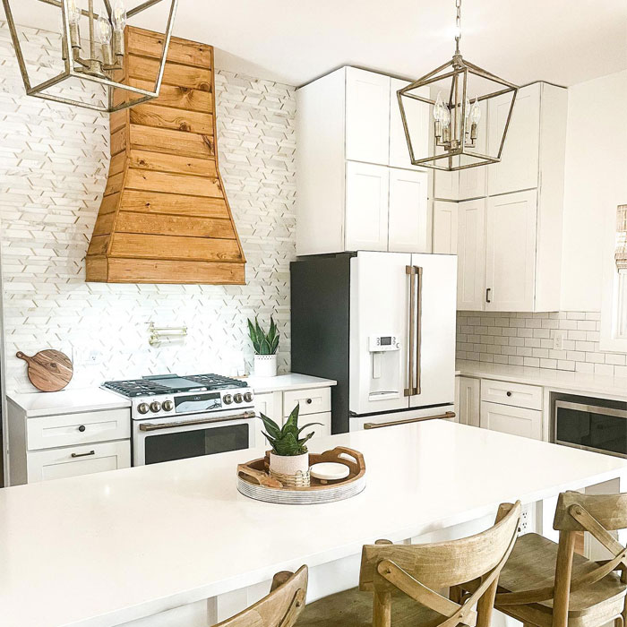 Bright white kitchen featuring a wooden range hood stained in Minwax Golden Oak wood stain color.