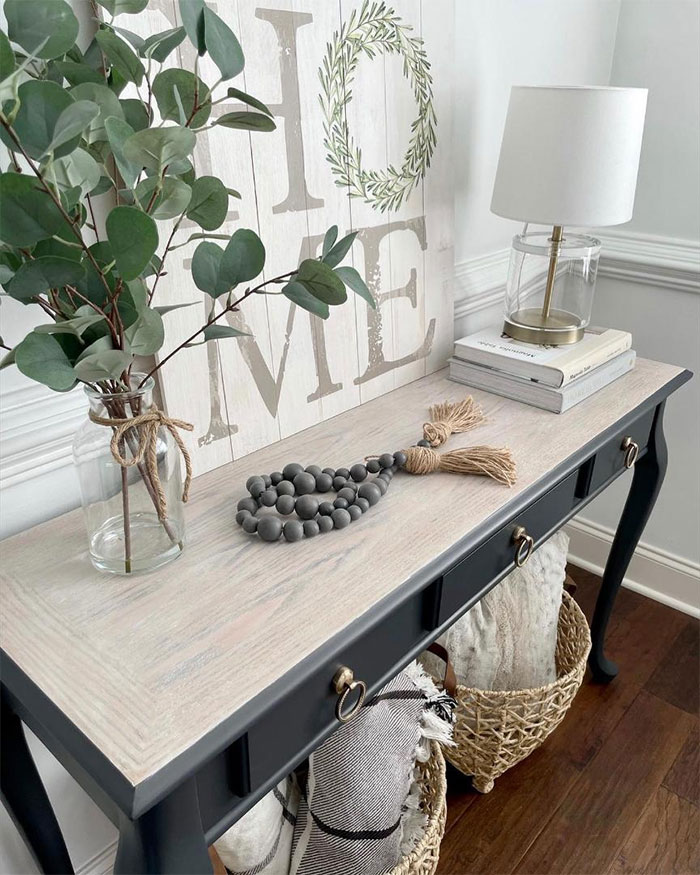 Black table stained with Minwax Tinsmith Gray wood stain in a cozy room setting with decorative items.