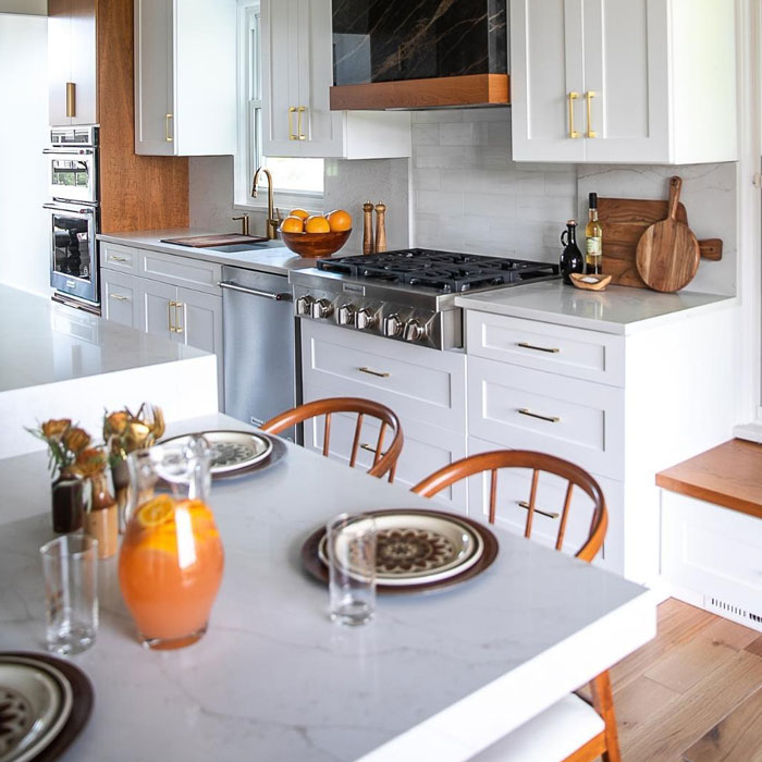Mid-century modern kitchen design with white cabinets, stainless steel appliances, and a marble countertop for timeless look.