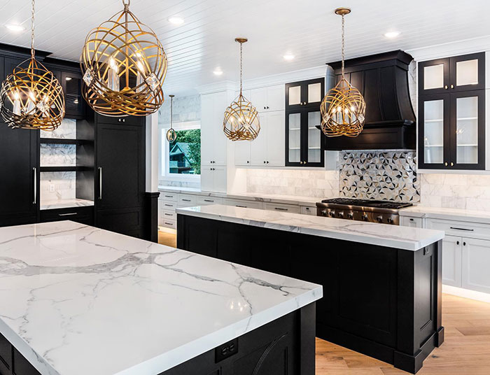 Black and white modern kitchen design with marble countertops and decorative pendant lights for a timeless look
