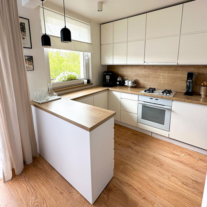 Small cozy bright kitchen with modern kitchen design featuring white cabinets and wood countertops for a timeless look