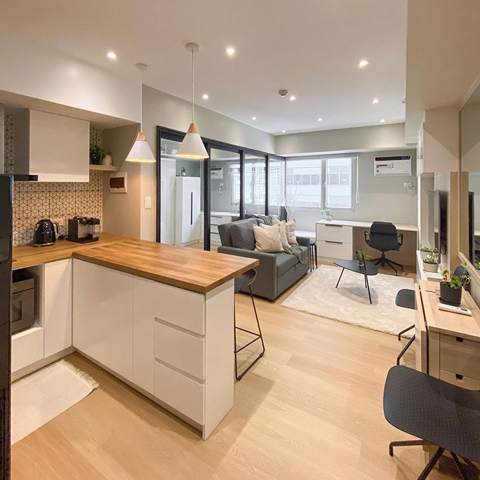Open spaced modern kitchen design with wooden countertops and a cozy living area creating a timeless kitchen look.