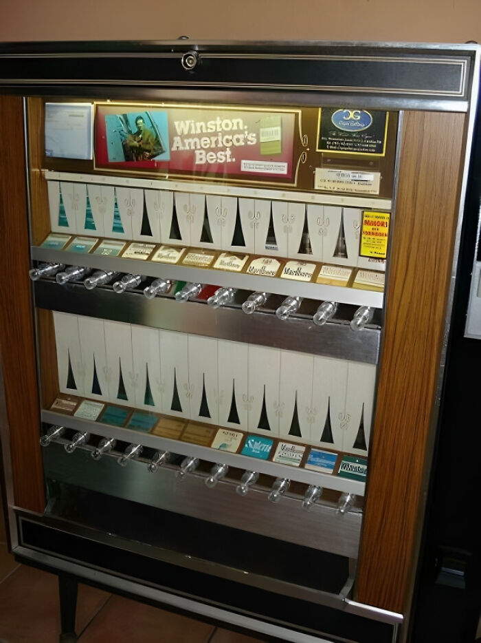Vintage cigarette vending machine with classic packs, illustrating painfully funny signs of people getting old faster than expected.