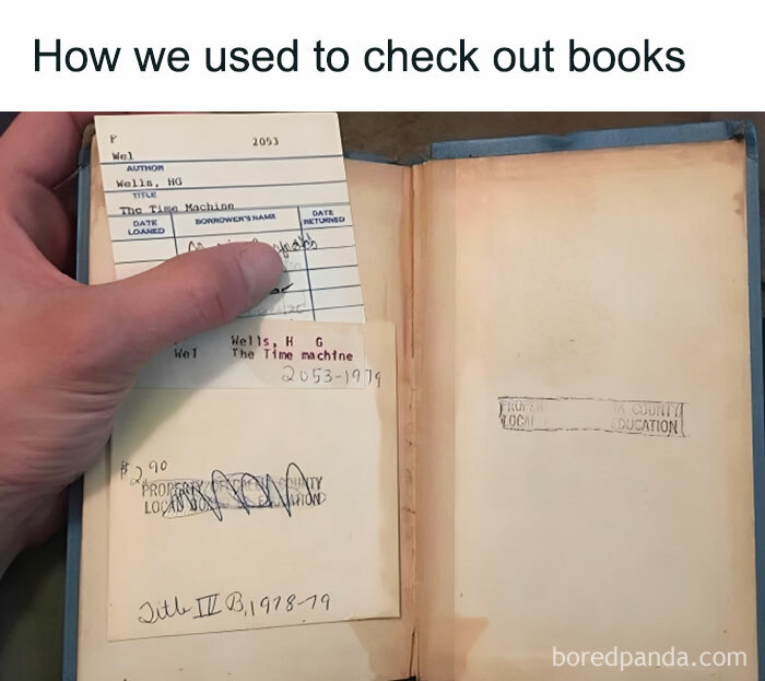 Hand holding an old library book with dated check-out cards, showcasing vintage ways people are getting old faster.