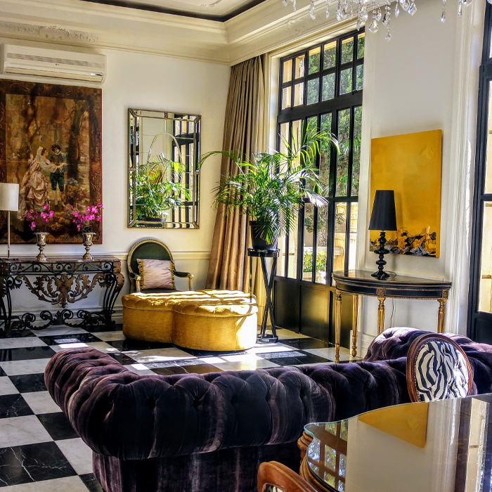 Luxurious living room featuring old money interior design with a purple sofa and crystal chandelier in elegant setting Luxurious living room featuring old money interior design with a purple sofa and crystal chandelier in elegant setting