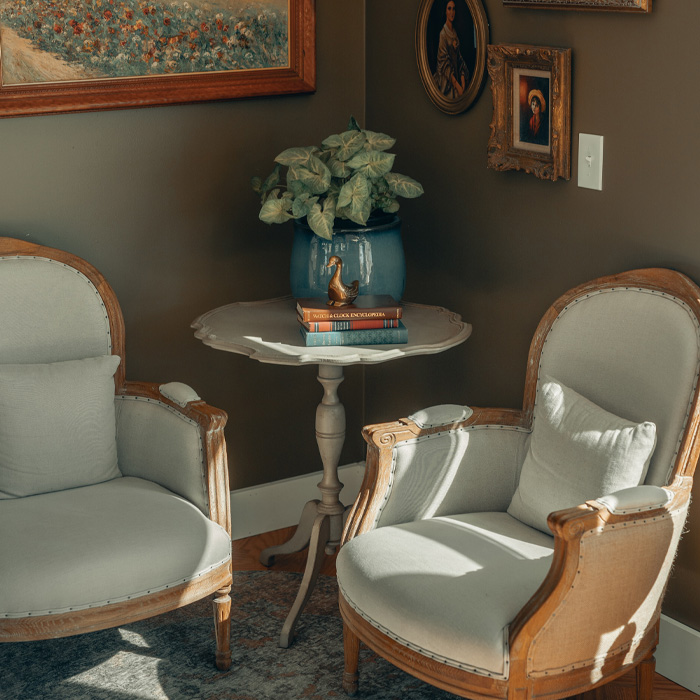 White and brown wooden framed padded armchairs in classic old money interior design style with elegant vintage decor. White and brown wooden framed padded armchairs in classic old money interior design style with elegant vintage decor.