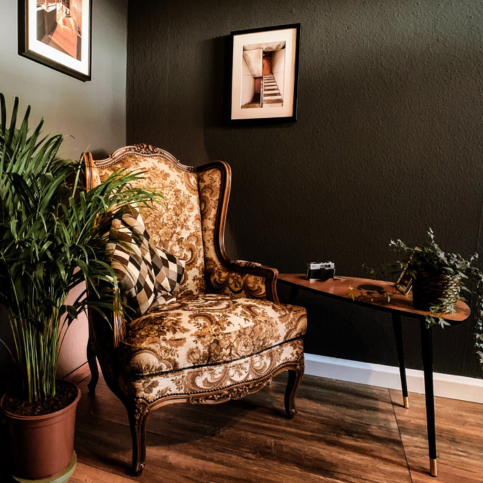 Winged chair with vintage floral upholstery near console table in an elegant old money interior design setting Winged chair with vintage floral upholstery near console table in an elegant old money interior design setting