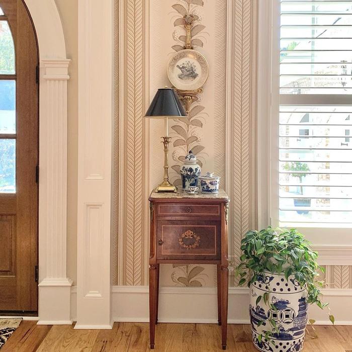 Wooden nightstand with brass lamp and blue porcelain vases in old money interior design style living space. Wooden nightstand with brass lamp and blue porcelain vases in old money interior design style living space.